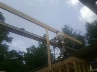 Carpenter setting a ridge beam over a new addition frame — Ice Dam Removal by Roofing Brothers in Ulster