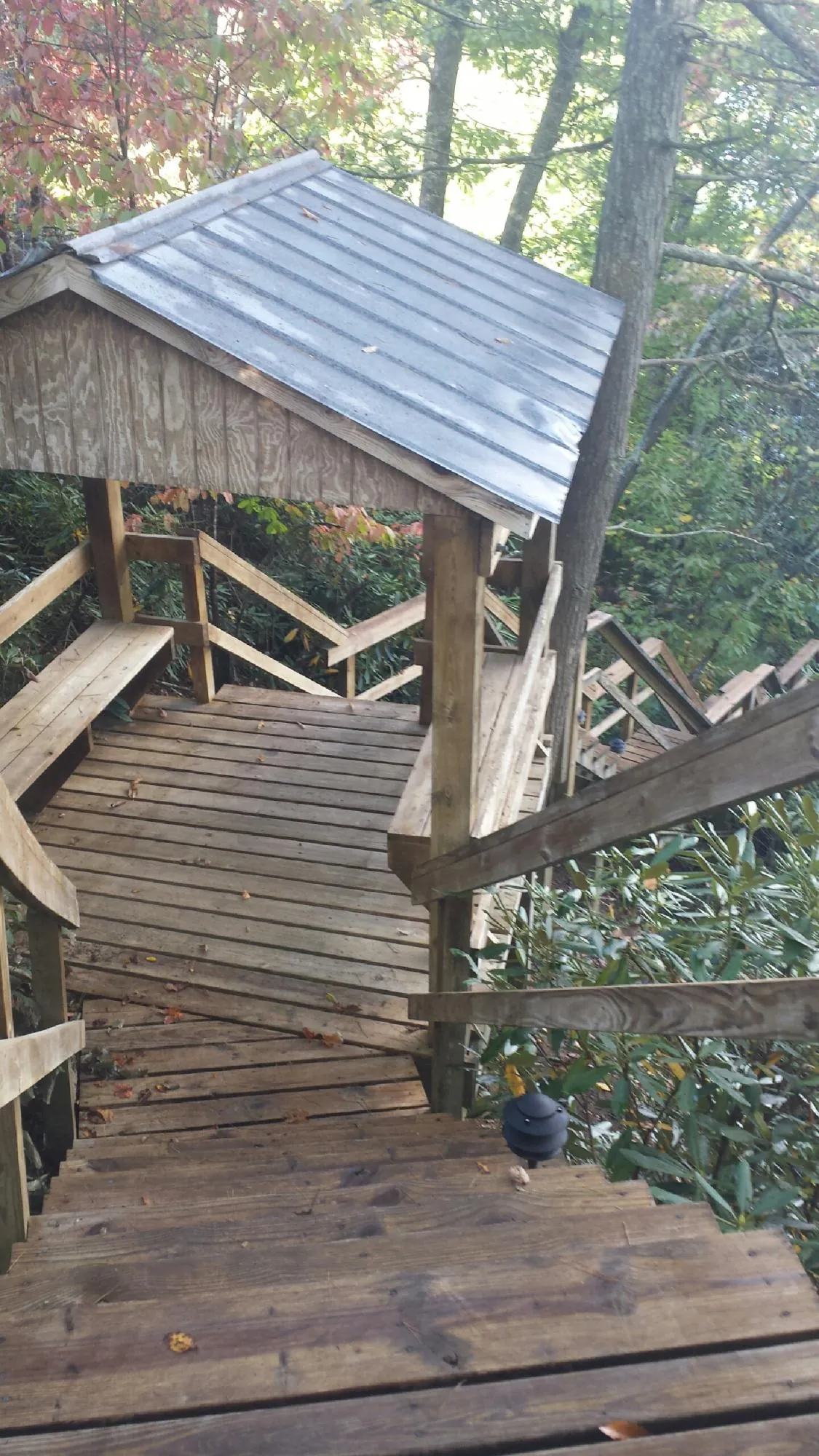 Metal roofed shelter over wooden steps on a wooded walkway — Skylight Repair & Installation work by our crew in Ulster