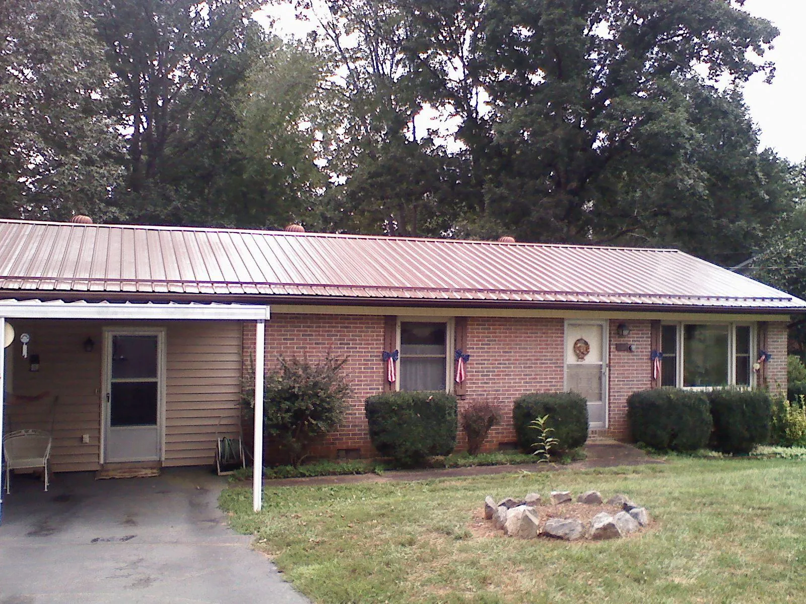 Bronze metal roof and carport on a brick ranch home — Roof Repair work by our crew in Ulster
